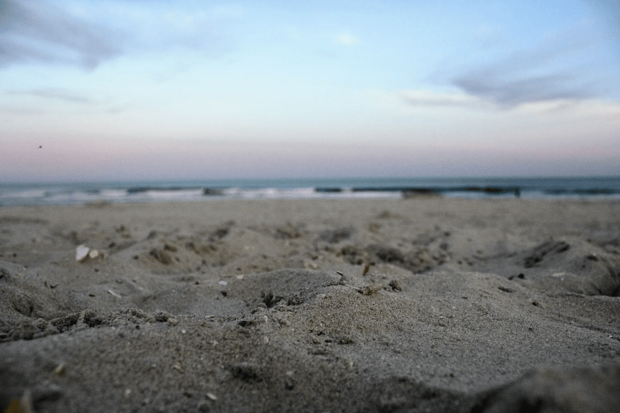 Close sand and a soft Ocean City shoreline at dusk.